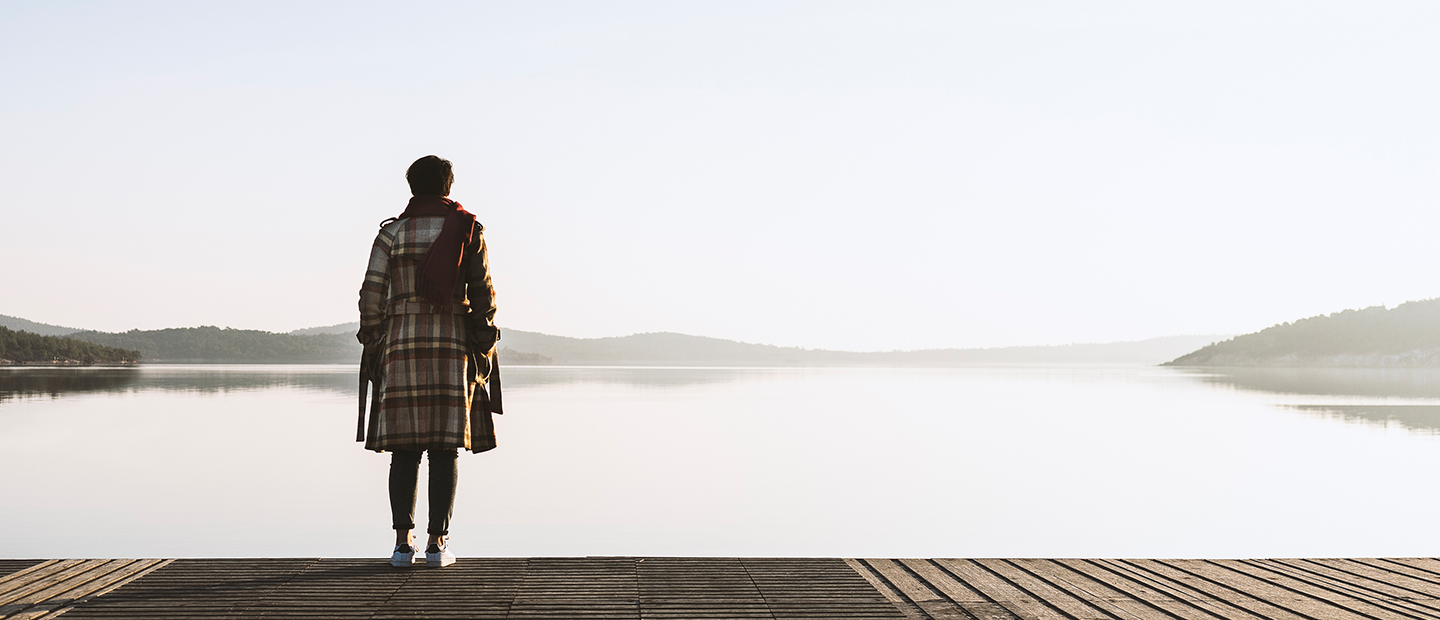 Depression, Melancholie - Frau steht auf einem Steg und blickt auf See Foto: Depression, Melancholie - Frau steht auf einem Steg und blickt auf See