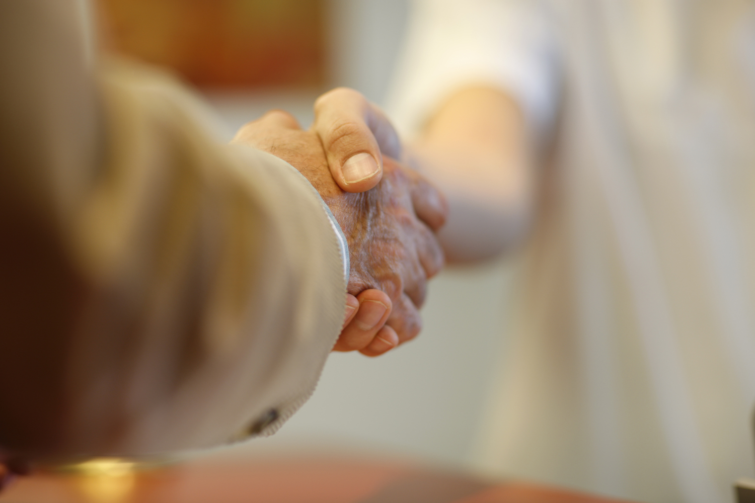 Händeschütteln Mitarbeiter und Patient schütteln sich die Hände
