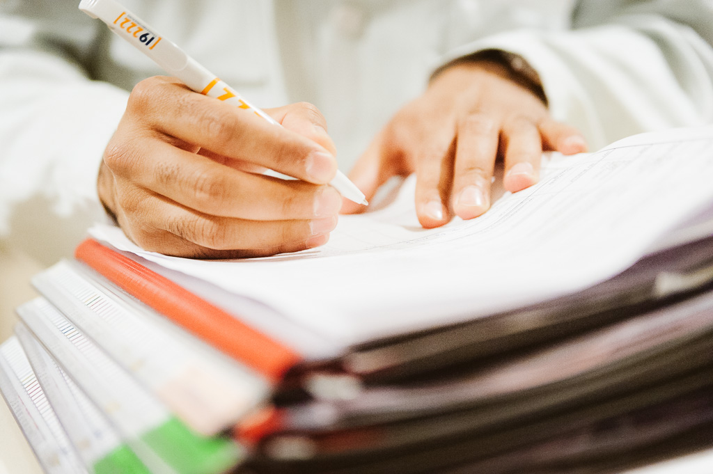 Arzt schreibt in Patientenakte Arzt schreibt in Patientenakte